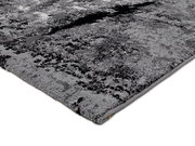 Nahaufnahme eines modernen, grauen Teppichs mit abstraktem Muster, perspektivisch von der Seite aufgenommen.