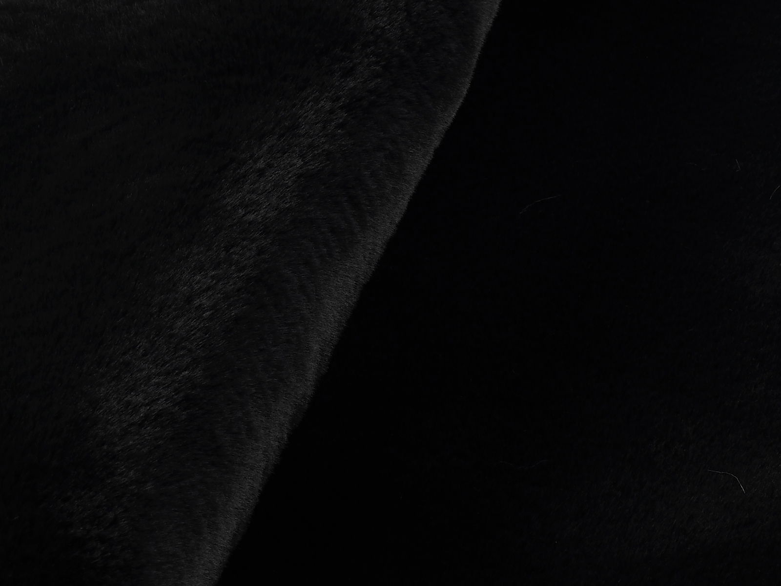 Nahaufnahme eines schwarzen Fellteppichs aus seitlicher Perspektive