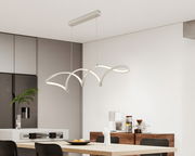 Moderne LED-Hängeleuchte mit geschwungenem Design, in einem Esszimmer von der Seite betrachtet.