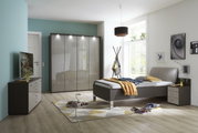 Panoramaschrank in einem modernen Schlafzimmer, frontal betrachtet, mit glänzenden Türen und integrierter Beleuchtung.