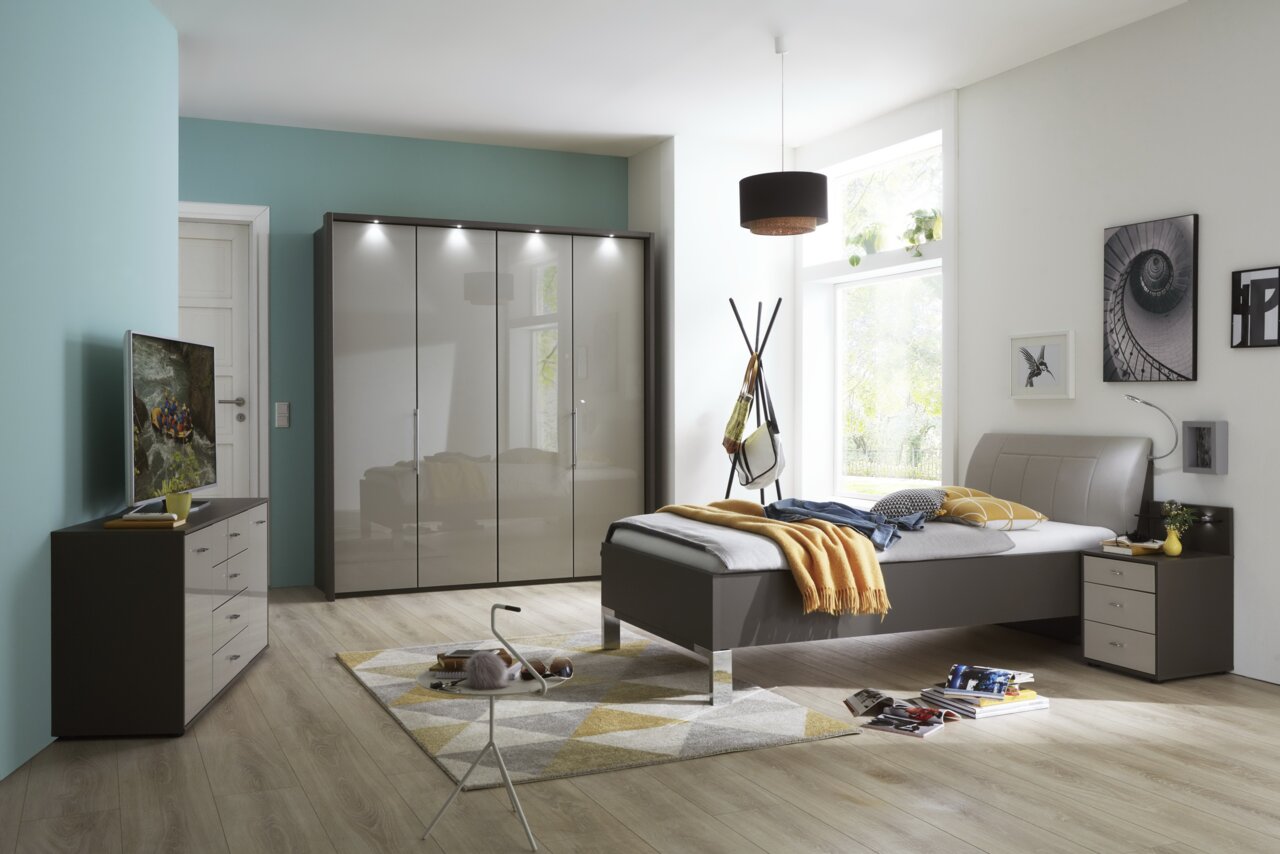 Panoramaschrank in einem modernen Schlafzimmer, frontal betrachtet, mit glänzenden Türen und integrierter Beleuchtung.