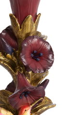Detailansicht eines kunstvoll gestalteten Kerzenständers mit roten Blüten und goldenen Akzenten.