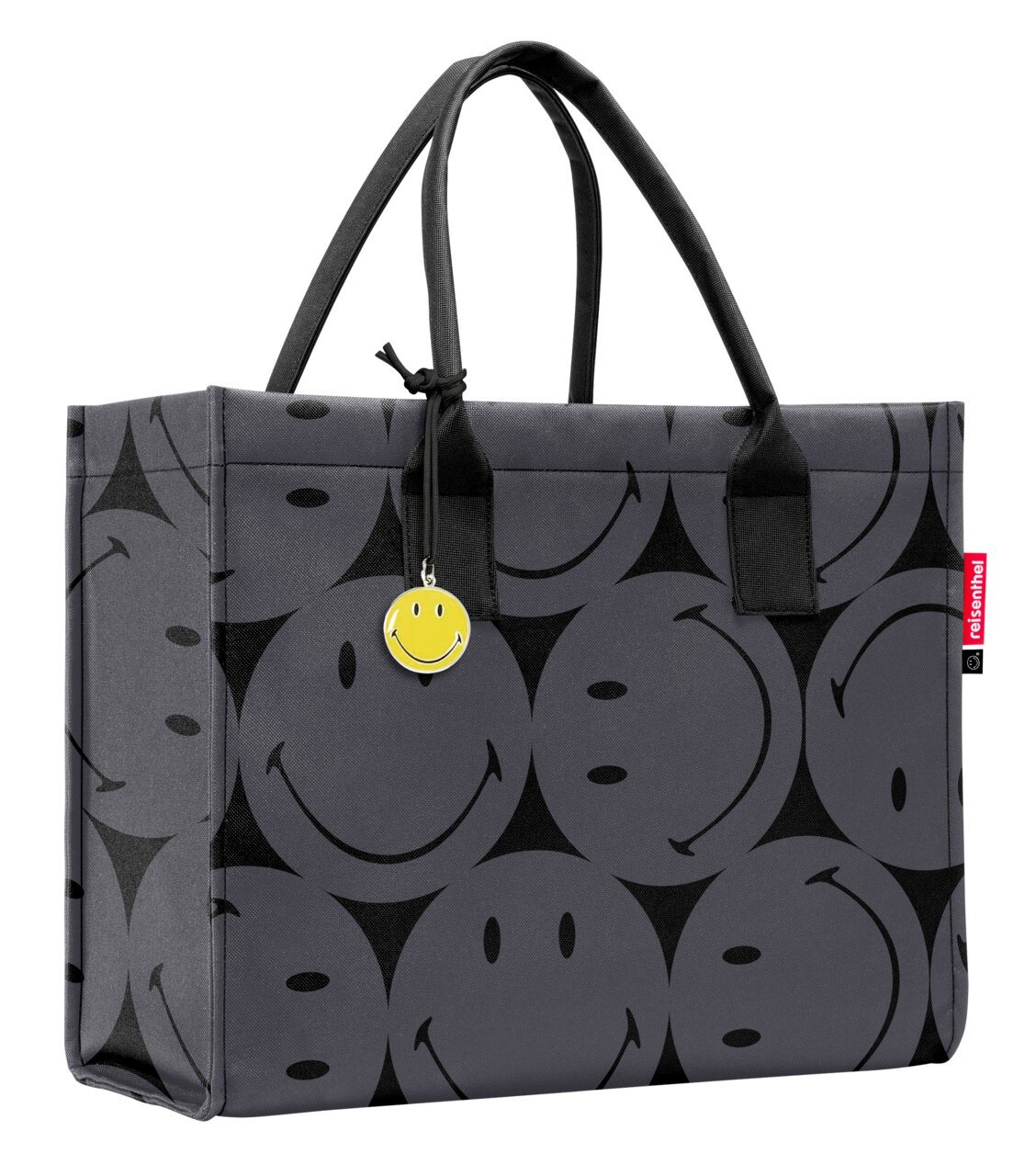 Graue Einkaufstasche mit schwarzen Smiley-Motiven und einem gelben Smiley-Anhänger, seitliche Perspektive