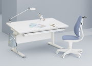 Moderner Jugenddrehstuhl in Blau und Weiß, seitliche Perspektive, neben einem weißen Schreibtisch mit Lampe und Schreibutensilien.