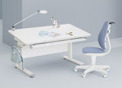 Moderne draaistoel voor jongeren in blauw en wit, gezien vanaf de zijkant, naast een wit bureau met een lamp en schrijfbenodigdheden.