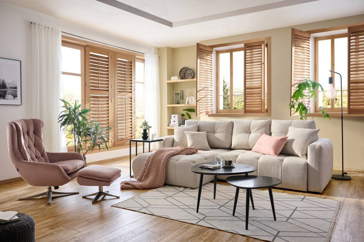 Ecksofa London in einem modernen Wohnzimmer mit großen Fenstern, Holzböden und stilvollen Möbeln, seitliche Perspektive