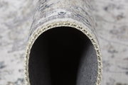 Nahaufnahme eines zusammengerollten Teppichs mit sichtbarer Kante und Textur, Perspektive von der Seite