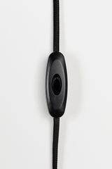 Nahaufnahme eines schwarzen Kabelschalters an einem schwarzen Kabel, vertikale Perspektive