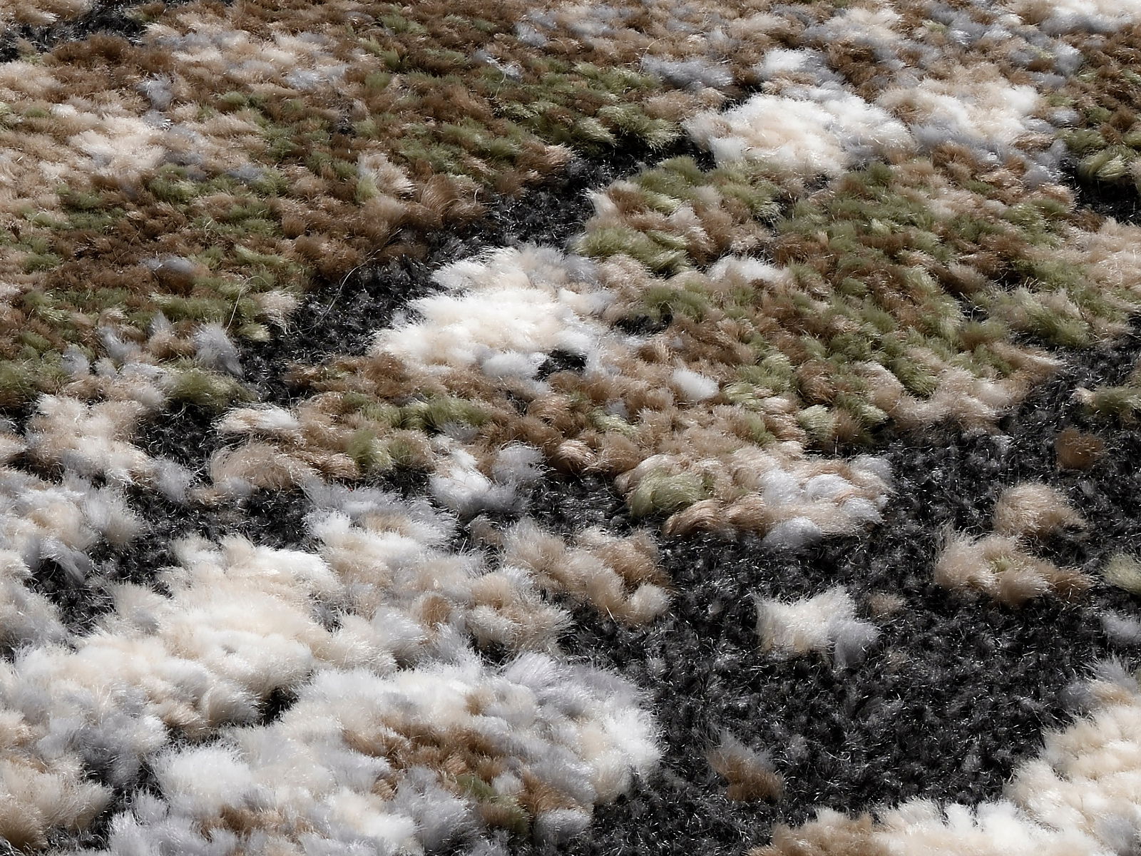 Nahaufnahme eines Designer-Teppichs mit flauschiger Textur in Erdtönen wie Grün, Braun, Weiß und Schwarz, aus seitlicher Perspektive aufgenommen.