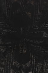 Nahaufnahme der dunklen Holzmaserung eines Esstisches aus der Vogelperspektive.