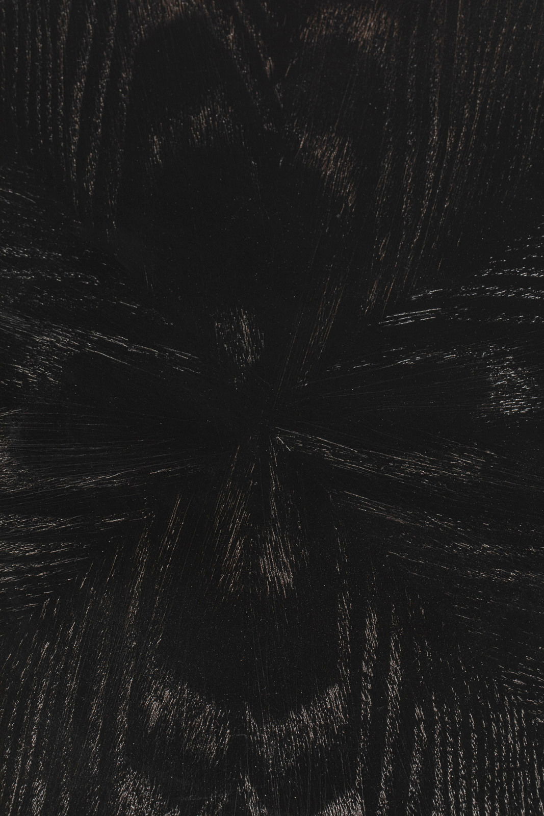 Nahaufnahme der dunklen Holzmaserung eines Esstisches aus der Vogelperspektive.