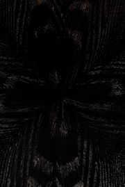 Nahaufnahme der dunklen Holzmaserung eines Esstisches aus der Vogelperspektive.