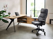 Moderner Eck-Schreibtisch aus Holz mit schwarzem Metallgestell, seitlich von einem bequemen grauen Bürostuhl begleitet, in einem hellen Raum mit großen Fenstern.