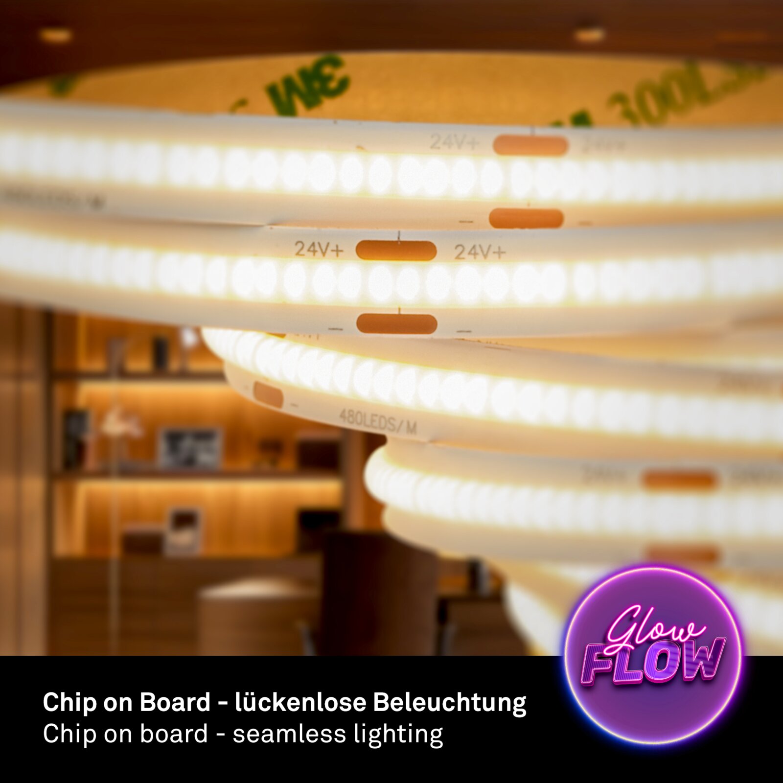 Nahaufnahme aus leicht schräger Seitenperspektive auf einen leuchtenden COB-LED-Streifen auf einer Rolle, mit Aufdruck 24V+ und 480 LEDs/m, für lückenlose Beleuchtung