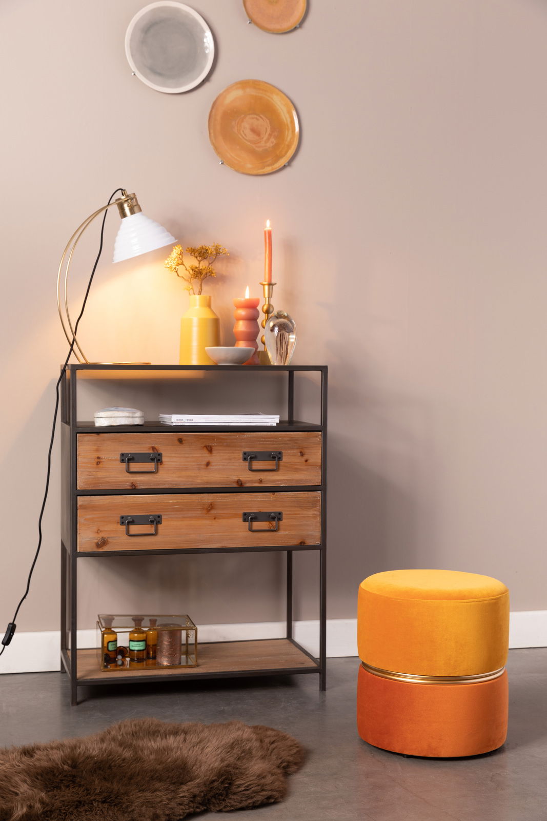 Z2 Hocker BUBBLY Hocker BUBBLY in leuchtendem Gelb und Orange, seitliche Perspektive, neben einem rustikalen Regal mit Dekorationen.