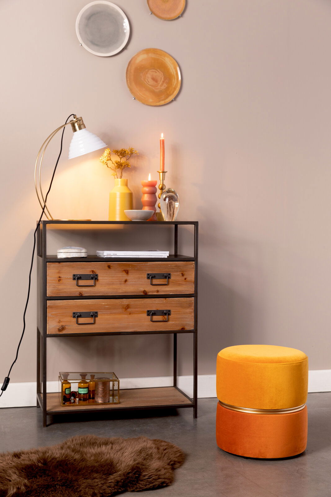 Z2 Hocker BUBBLY Hocker BUBBLY in leuchtendem Gelb und Orange, seitliche Perspektive, neben einem rustikalen Regal mit Dekorationen.