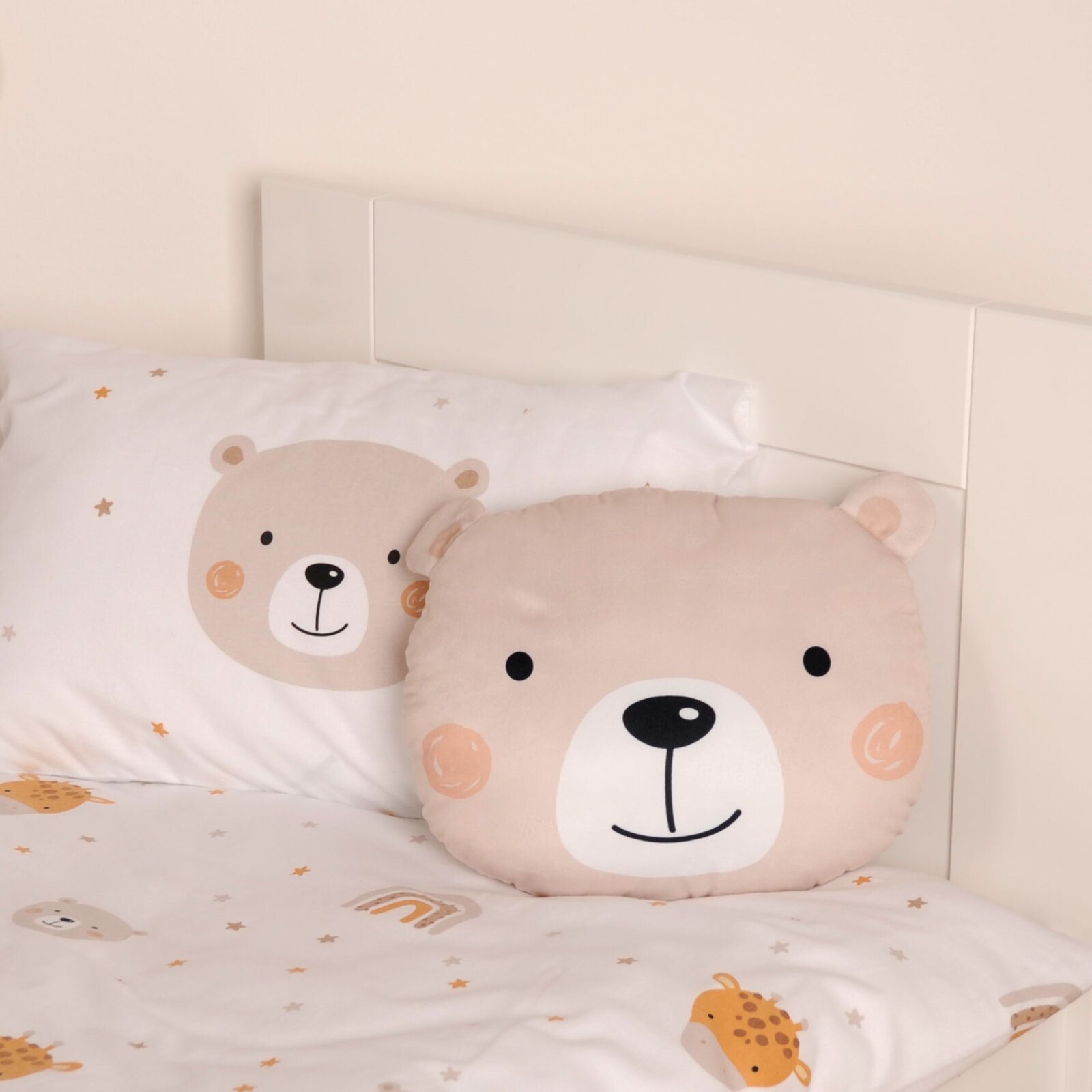 Bär-Formkissen in Beige auf einem Bett, frontal fotografiert, mit passender Bettwäsche im Bärendesign.