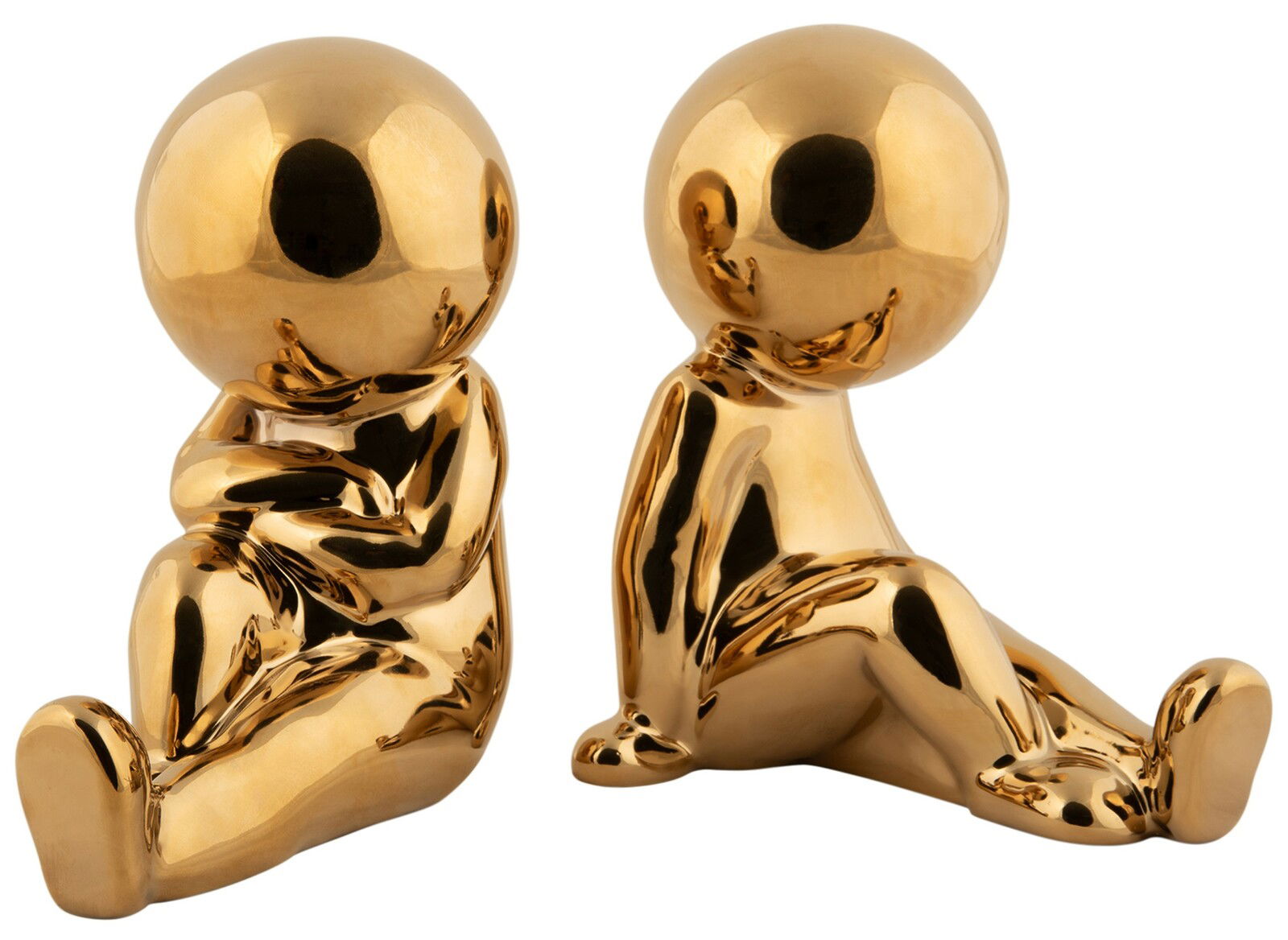 Zwei goldene Buchstützen in Form von stilisierten Figuren, die auf dem Boden sitzen. Die Figuren sind aus glänzendem Material und in einer frontalen Perspektive abgebildet.