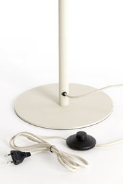 Nahaufnahme einer Stehleuchte mit rundem Sockel, Kabel und Fußschalter.