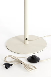 Close-up van een staande lamp met ronde voet, snoer en voetschakelaar.