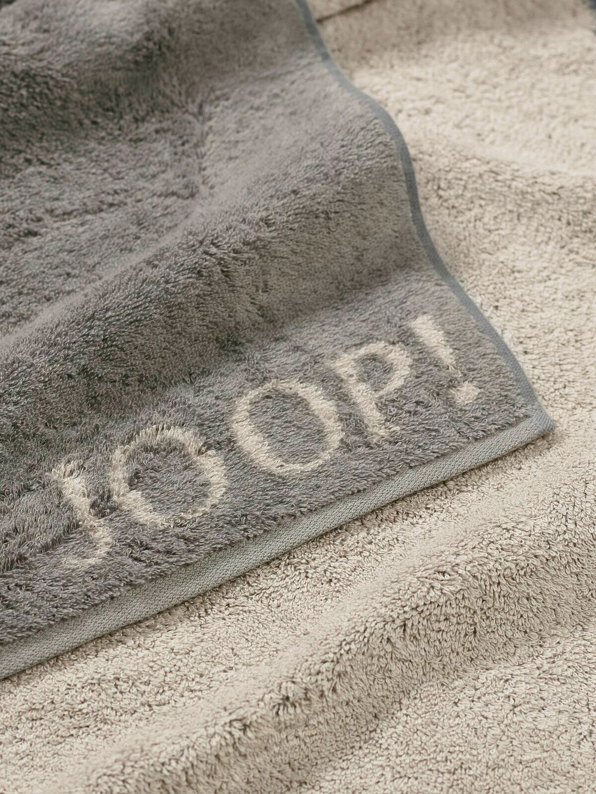 JOOP! Handtuch DOUBLEFACE CLASSIC Graues Gästetuch mit eingewebtem Schriftzug 'JOOP!' in Nahaufnahme