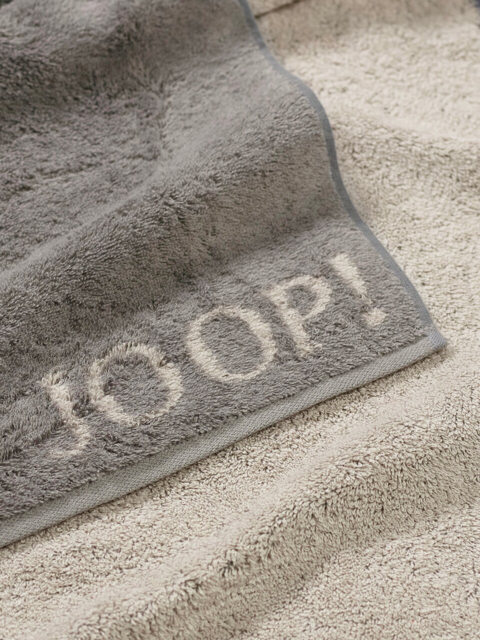 JOOP! Handdoek DOUBLEFACE CLASSIC Grijze gastendoek met ingeweven 'JOOP!'-opschrift in close-up