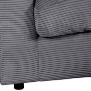 Nahaufnahme einer grauen Rundecke mit geripptem Stoffbezug, perspektivisch von der Seite aufgenommen.