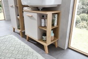 Moderner Waschbeckenunterschrank aus Holz mit offenen Regalfächern und einer Tür, seitliche Perspektive