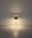 Moderne Tischleuchte mit schlichtem Design, frontal abgebildet, strahlt warmes Licht aus.
