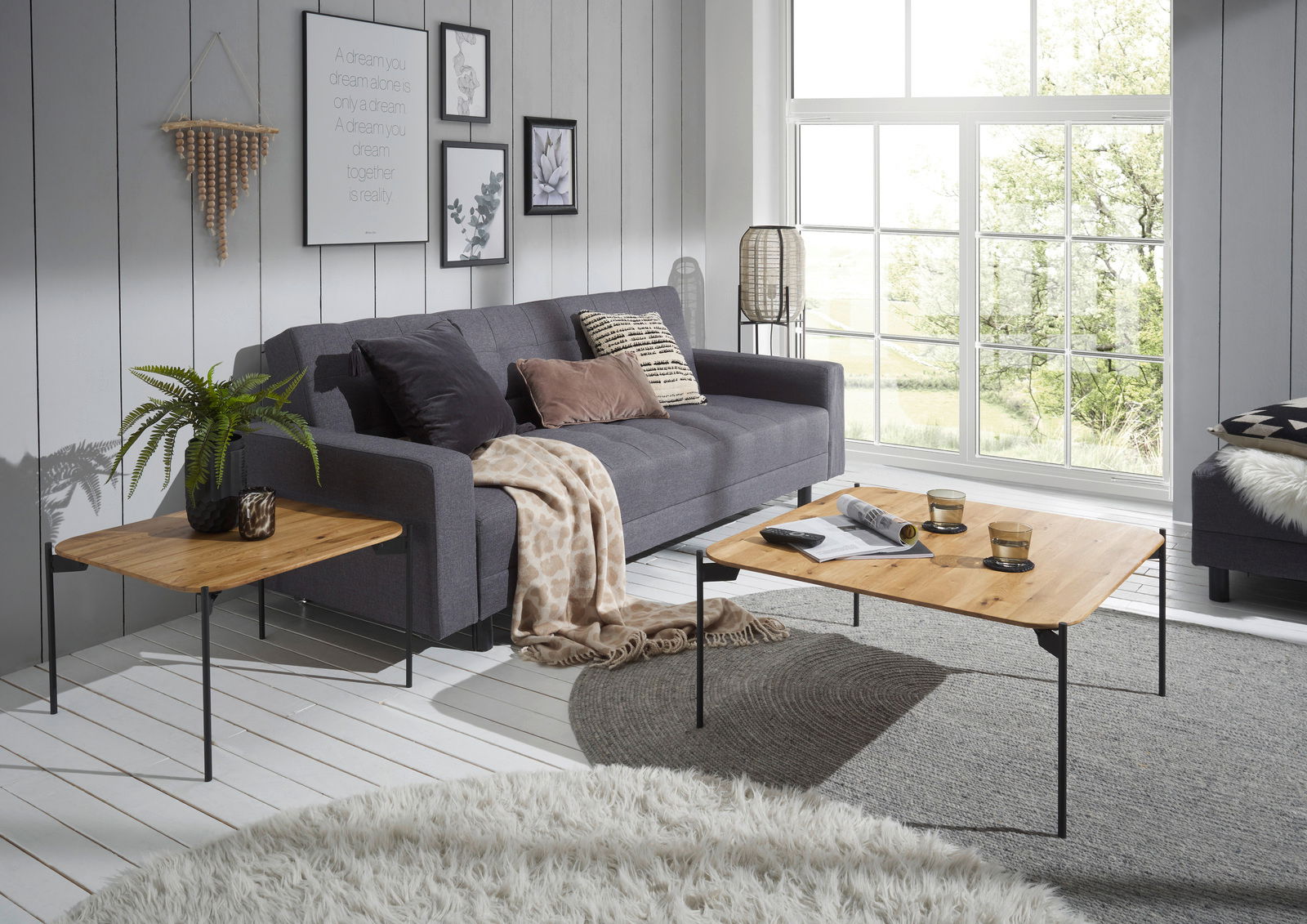 Moderner Couchtisch mit Holzplatte und schwarzen Metallbeinen in einem stilvollen Wohnzimmer, seitliche Perspektive.