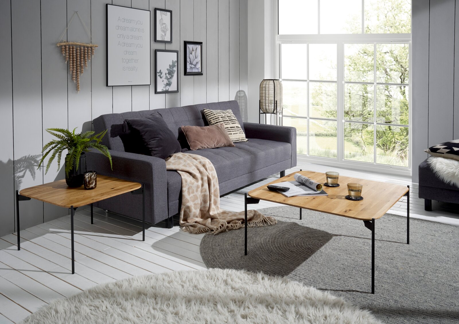 Moderner Couchtisch mit Holzplatte und schwarzen Metallbeinen in einem stilvollen Wohnzimmer, seitliche Perspektive.