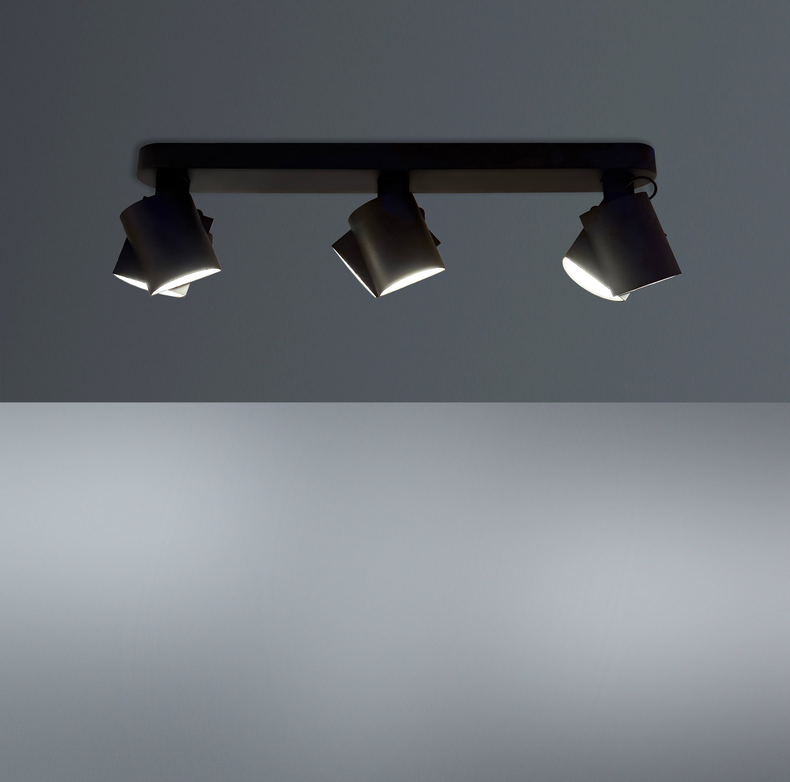 Dreifacher LED-Spot von unten betrachtet, montiert an einer Deckenleiste, mit modernem Design und verstellbaren Leuchten.