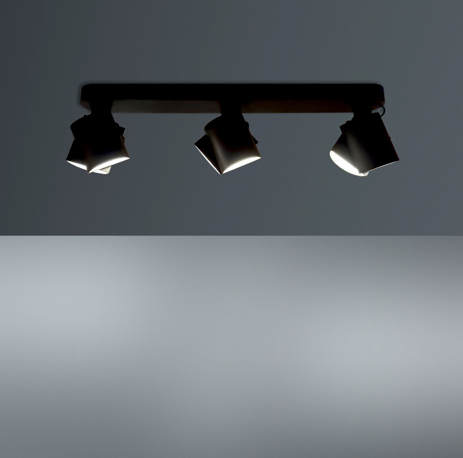 Dreifacher LED-Spot von unten betrachtet, montiert an einer Deckenleiste, mit modernem Design und verstellbaren Leuchten.