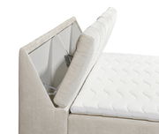 Seitliche Perspektive auf ein Boxspringbett mit hochgeklapptem Kopfteil und sichtbarem Stauraum.