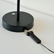 Zwarte accu-tafellamp met ronde voet en USB-aansluiting, zijaanzicht.