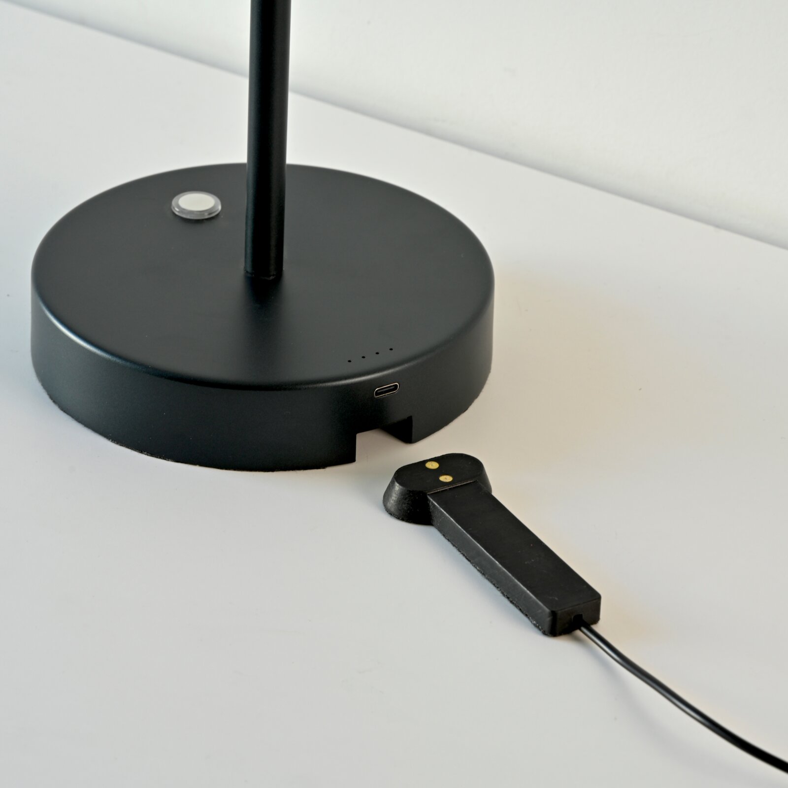 Zwarte accu-tafellamp met ronde voet en USB-aansluiting, zijaanzicht.