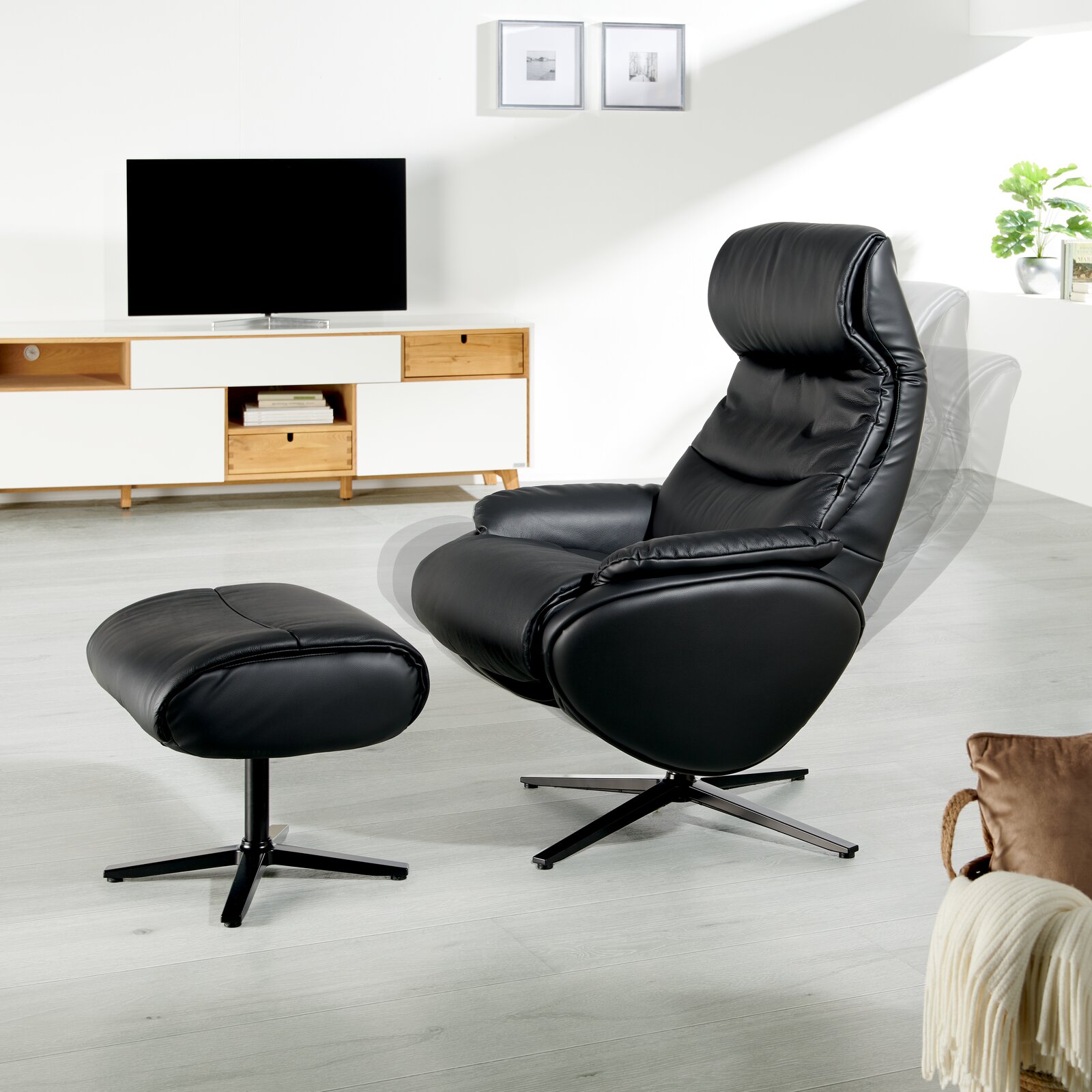 Schwarzer Relaxsessel mit Hocker in einem modernen Wohnzimmer, seitliche Perspektive