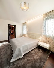 Moderne Deckenleuchte mit Kristallanhängern in einem stilvollen Schlafzimmer, Perspektive von unten.