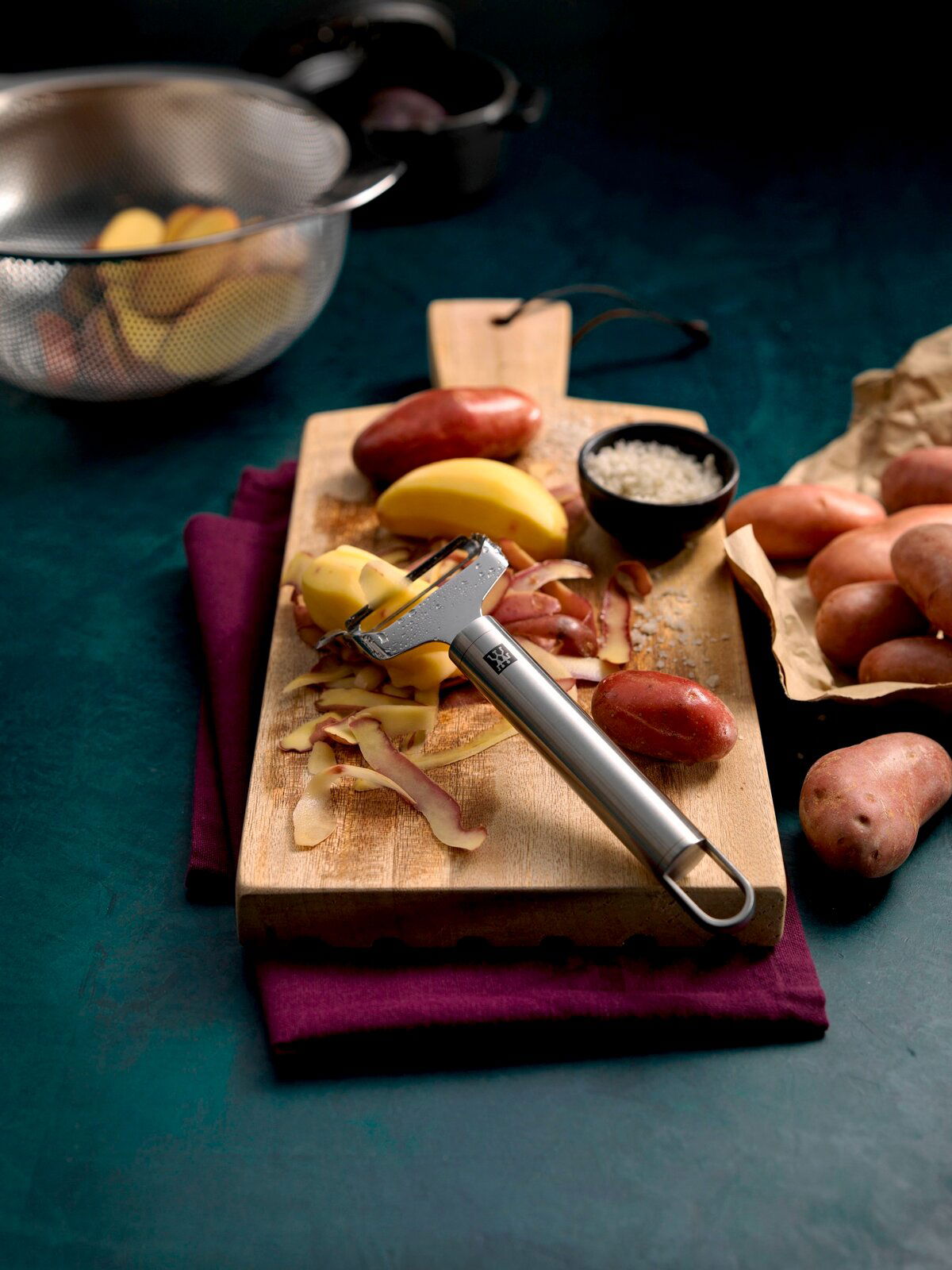 ZWILLING Pendelschäler quer ZWILLING PRO Pendelschäler quer Pro auf einem Schneidebrett mit Kartoffeln, von oben fotografiert.