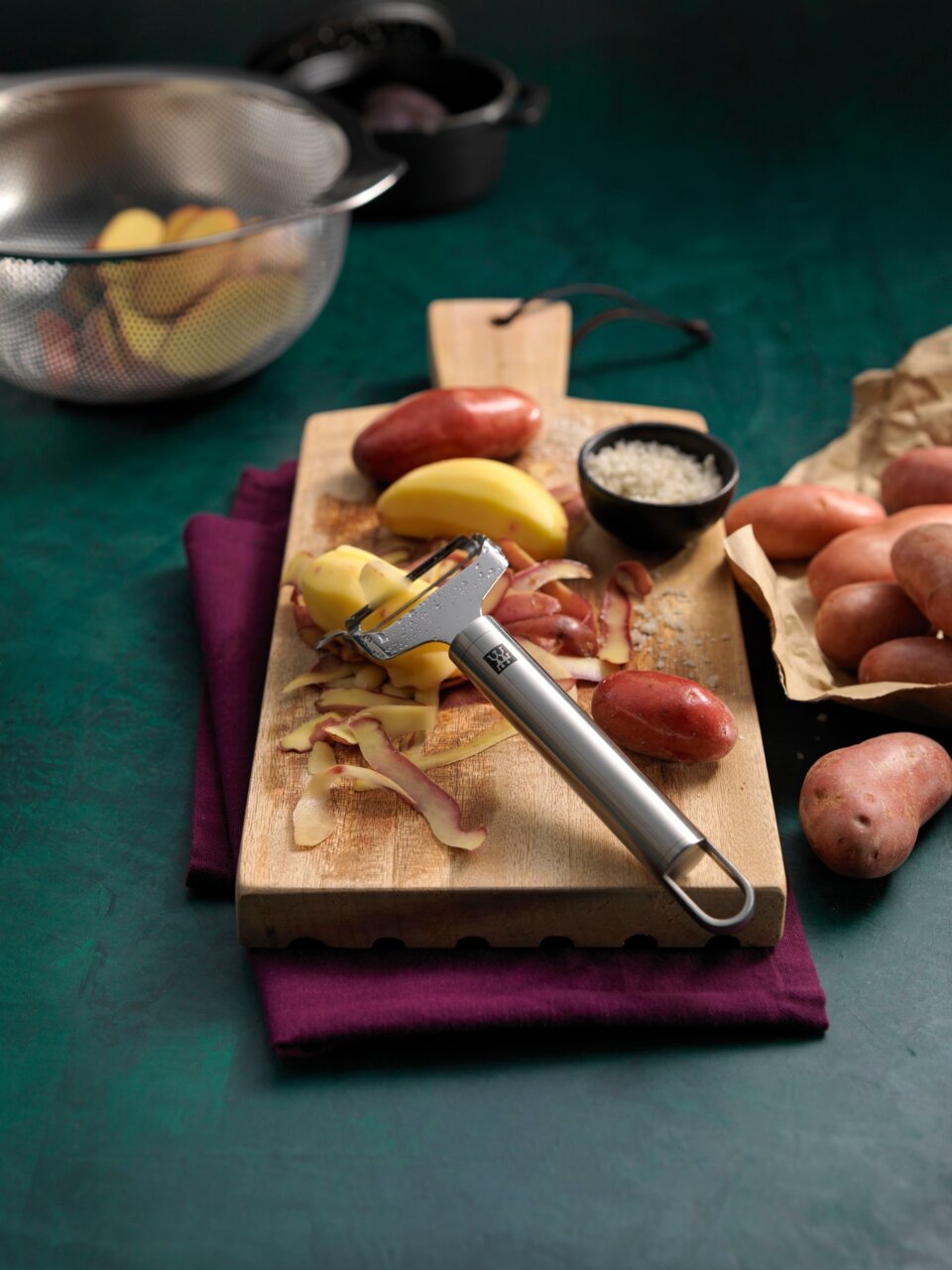 ZWILLING Pendelschäler quer ZWILLING PRO Pendelschäler quer Pro auf einem Schneidebrett mit Kartoffeln, von oben fotografiert.