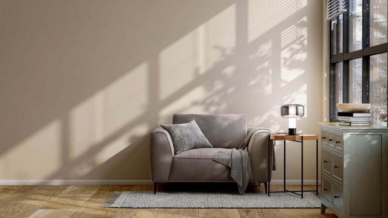 Fabas Luce Tischleuchte FLICK Moderne Tischleuchte auf einem Beistelltisch neben einem grauen Sessel, seitliche Perspektive