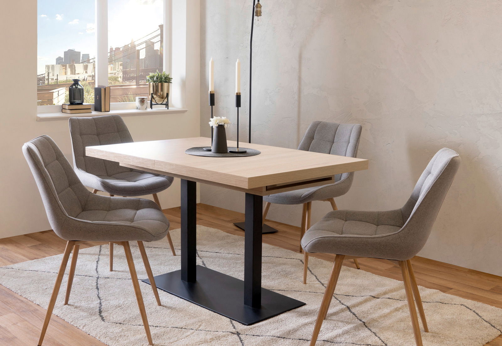 Z2 Esstisch QUADRATO Moderner Esstisch mit hellem Holz und schwarzem Metallgestell, umgeben von vier grauen Polsterstühlen in einem hellen Raum mit Fenster im Hintergrund, seitliche Perspektive.