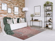 Designer Teppich in einem modernen Wohnzimmer mit Backsteinwand, Sofa und Dekorationen, aus der Vogelperspektive betrachtet.