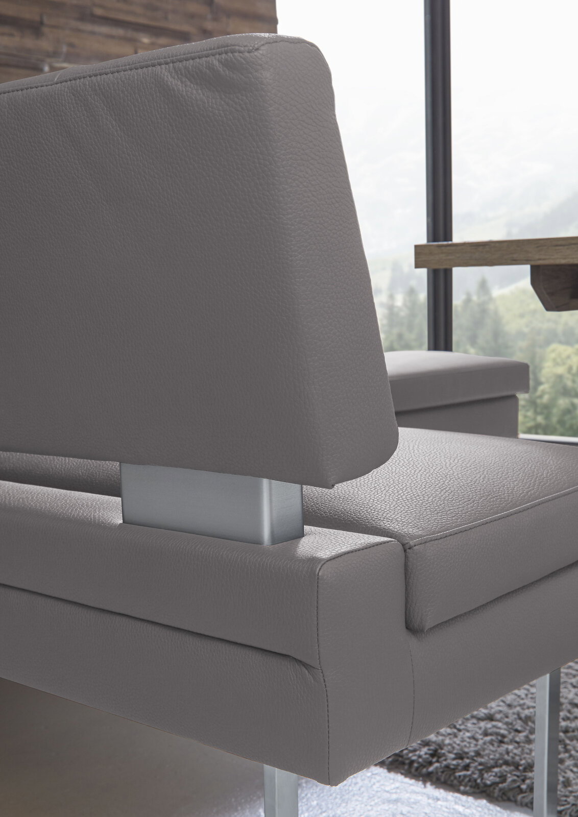 Detailansicht einer modernen grauen Eckbank mit Metallakzenten, seitliche Perspektive.