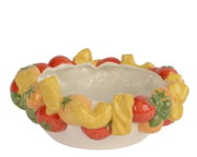 Bunte Keramikschale mit umlaufendem Obst- und Blätterrelief in Rot, Gelb und Grün, freigestellt auf Weiß, aus leicht erhöhter Frontperspektive (Draufsicht schräg).