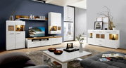 Moderne Wohnwand und Sideboard in einem stilvollen Wohnzimmer mit weißem Hochglanz-Finish und Holzakzenten, seitliche Perspektive.