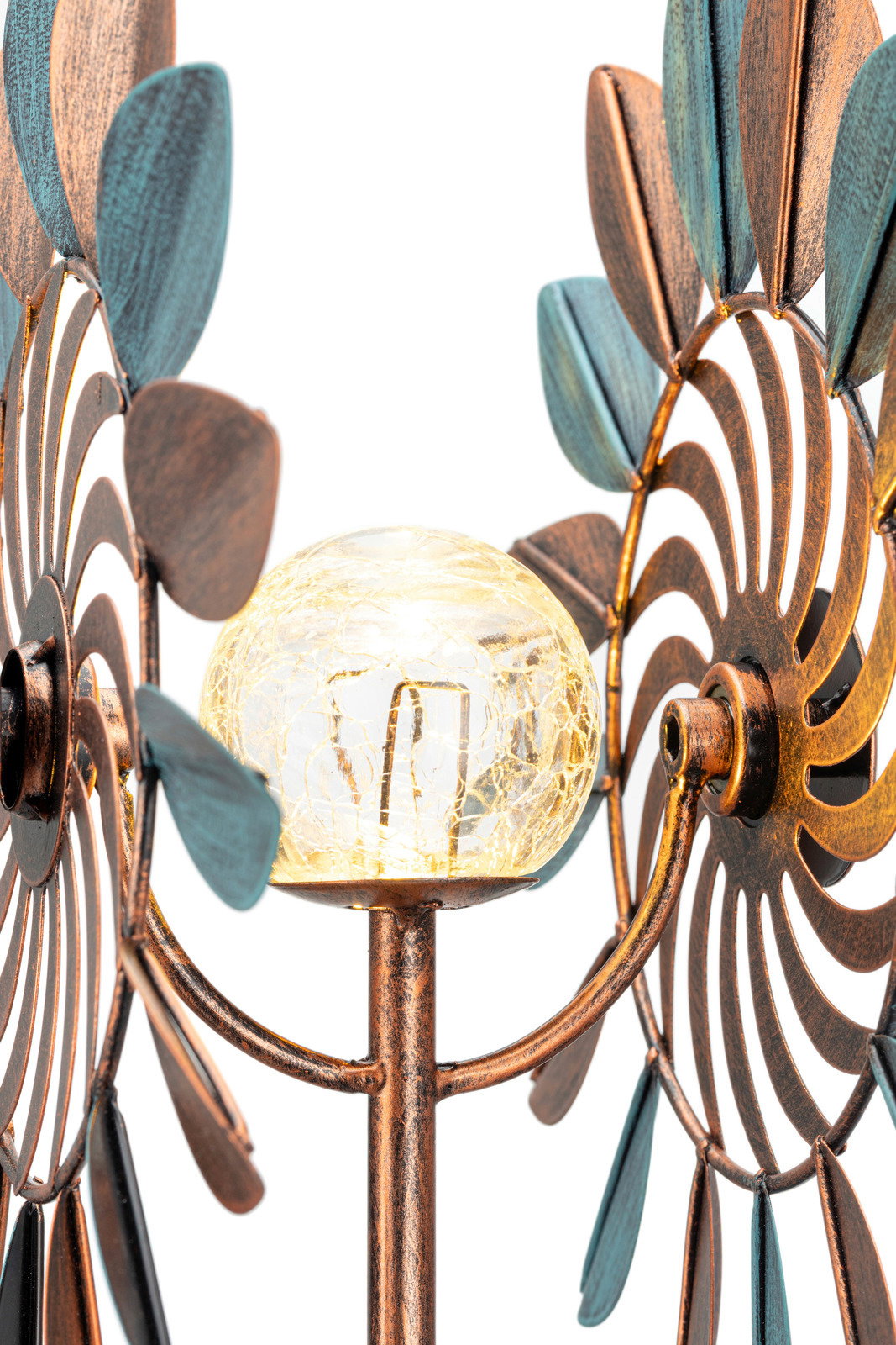 Nahaufnahme einer dekorativen Solarleuchte mit bronzefarbenen und blauen Metallblättern sowie einer gläsernen Kugel in der Mitte, aus seitlicher Perspektive.