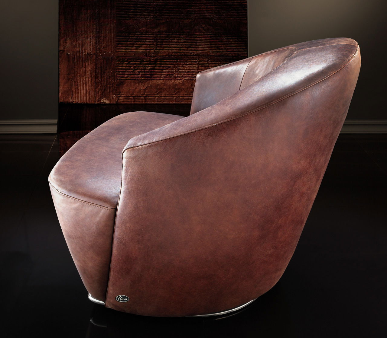 Brauner Ledersessel in Seitenansicht mit elegantem, modernem Design.