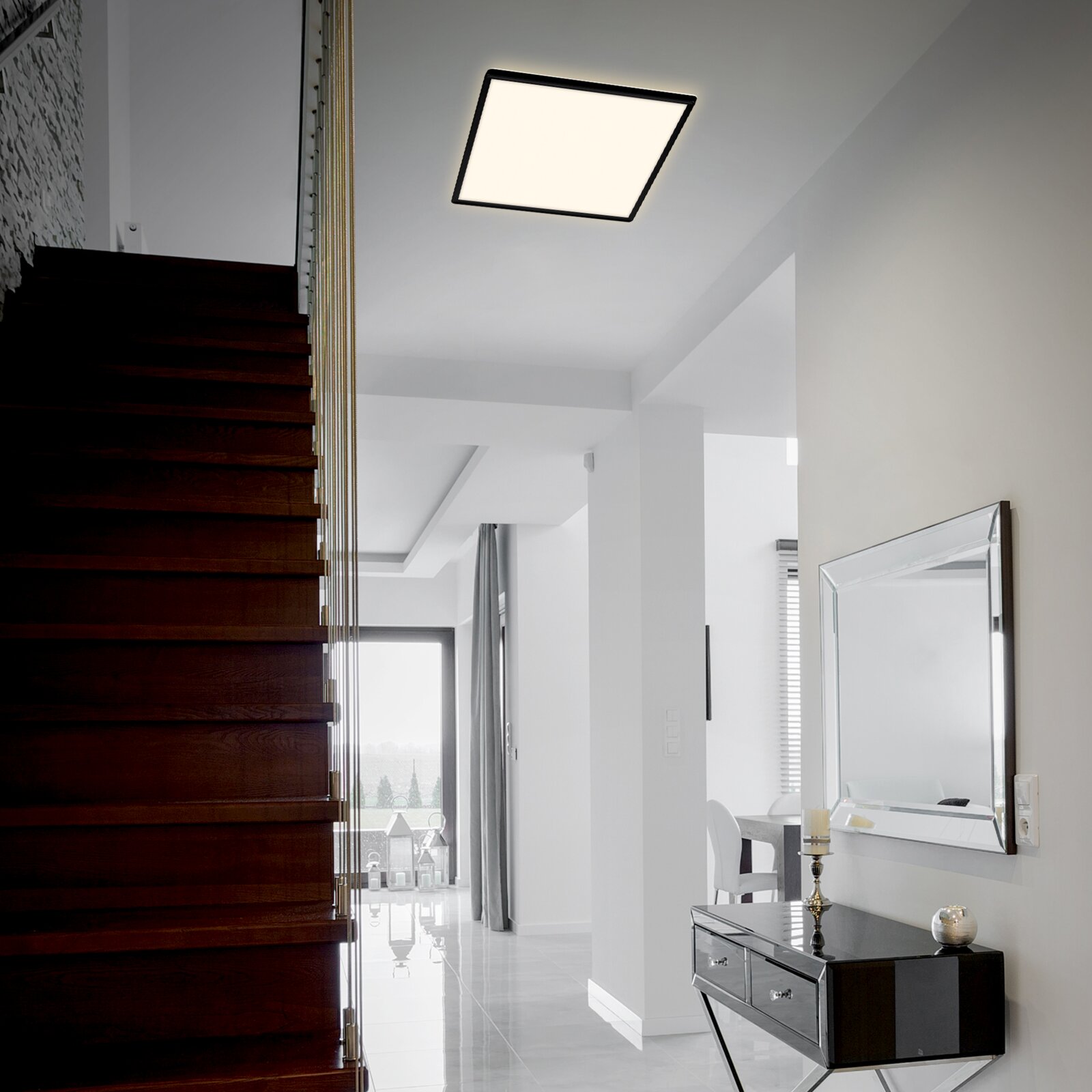 Moderne LED-Deckenleuchte in quadratischer Form, installiert in einem stilvollen, hellen Flur mit Treppenansicht.
