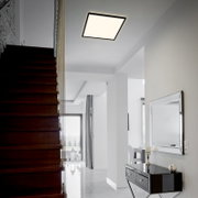 Moderne LED-Deckenleuchte in quadratischer Form, installiert in einem stilvollen, hellen Flur mit Treppenansicht.